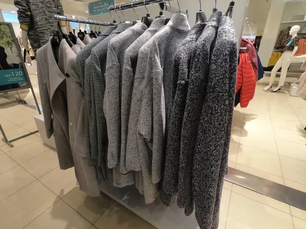 Dubai uae - April 2019 - Mäntel und Strickpullover hängen zum Verkauf. Textil-Sporthemden hängen in Reihe im Geschäft. — Stockfoto