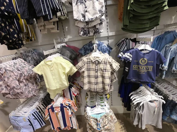 Dubai Bae, Haziran 2019: Çocuk giyim mağazası. Bir mağazada çocuk kıyafetleri, raflarda giysiler, ceketli askılar gösteren mankenler. Farklı renklerde çocuk giysileri. — Stok fotoğraf