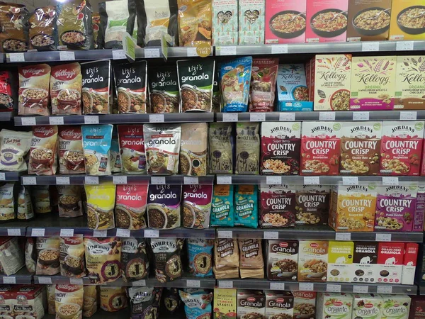 Dubai Emiratos Árabes Unidos - Mayo 2019: Una variedad de cereales de desayuno envasados en estantes en venta. Carriles de estantes con productos de mercancías en el interior. Departamento de cereales y desayuno. Granola envasada en la caja de papel, plasti — Foto de Stock