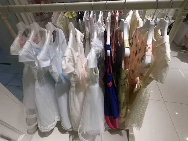 ドバイUAE - 7月2019:ハンガーに掛けられた子供服の列。店内の子供服。店内の布棚に吊るされたカラフルな子供服や岩の景色. — ストック写真