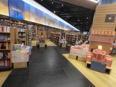 Dubai BAE - Temmuz 2019: Dubai 'deki en büyük perakende kitapçılarından biri olan Kinokuniya Kitap Mağazasında Satılık Ünlü Uluslararası Kitaplar. Kitapçıda iç mekan. Farklı renkli kitapların satırları.