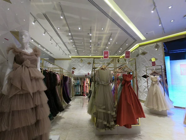 Dubai UAE - August 2019: Department of dresses in the women's clothing store. A lot of female Evening Gowns, dresses displayed for sale on hangers in a boutique clothing shop. — Stock Photo, Image