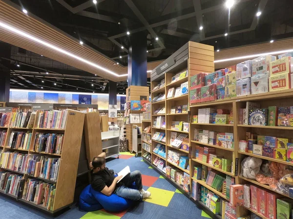 Dubai Uae - sierpień 2019: Człowiek w księgarni czytający. Mężczyzna siedzi w bibliotece. Mężczyzna czytający książki w bibliotece. . — Zdjęcie stockowe