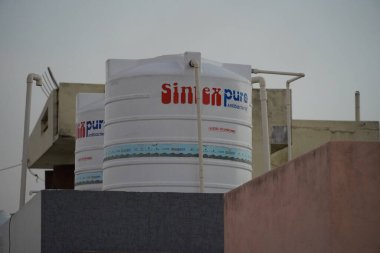Bir evin çatısındaki ikiz beyaz sinteks su tankı ya da çatı ya da güvertedeki endüstriyel bina. : Udaipur Hindistan - Haziran 2020 840