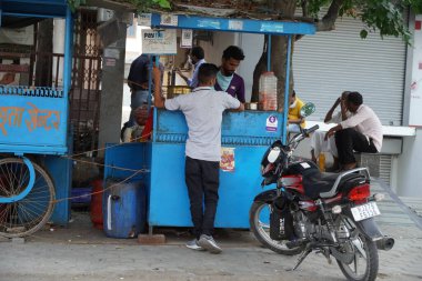 Hindistan sokaklarında geleneksel çay evi. Çay satıcısı çay ve alıcı hazırlıyor. Yüzünde maskeyle mesafeyi koruyor. Hindistan Mumbai. Sokaktaki en iyi çay. : Udaipur Hindistan - Haziran 2020 3JF