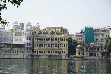 Göl kıyısındaki çok aile binaları. Apartman sakinlerine su ve doğa ile doğrudan temas sağlıyorlar. Udaipur Hindistan - Temmuz 2020