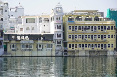 Göl kıyısındaki çok aile binaları. Apartman sakinlerine su ve doğa ile doğrudan temas sağlıyorlar. Udaipur Hindistan - Temmuz 2020 MCJ