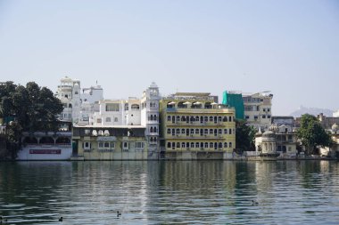 Göl kıyısındaki çok aile binaları. Apartman sakinlerine su ve doğa ile doğrudan temas sağlıyorlar. Udaipur Hindistan - Temmuz 2020 PEL