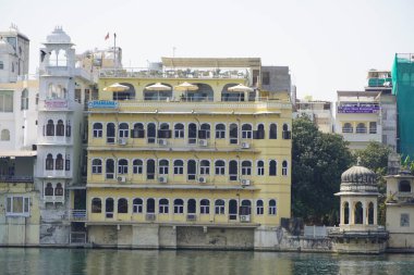 Göl kıyısındaki çok aile binaları. Apartman sakinlerine su ve doğa ile doğrudan temas sağlıyorlar. Udaipur Hindistan - Temmuz 2020 NCIE