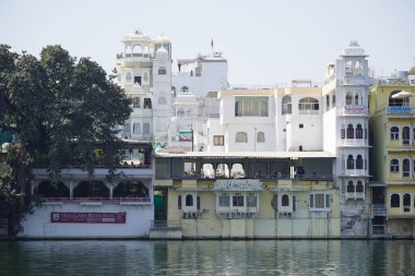 Göl kıyısındaki çok aile binaları. Apartman sakinlerine su ve doğa ile doğrudan temas sağlıyorlar. Udaipur Hindistan - Temmuz 2020 DNV