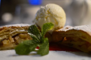 beyaz pudra şekeri ve vanilyalı dondurma bir kepçe ile toz ince bir gevrek kabuk ile elma dolması elma strudel