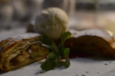 beyaz pudra şekeri ve vanilyalı dondurma bir kepçe ile toz ince bir gevrek kabuk ile elma dolması elma strudel