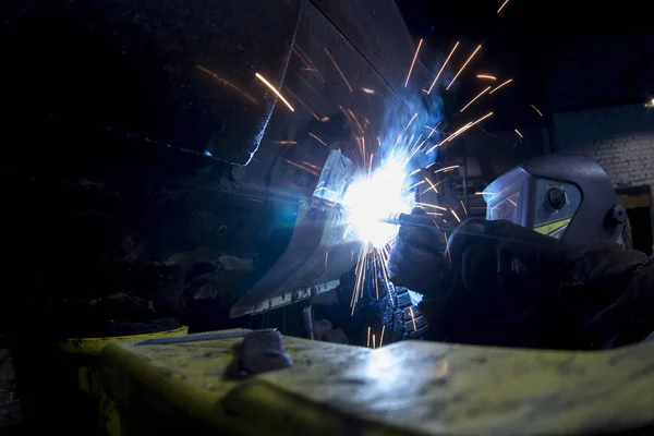 Welder welds car with welding-machine