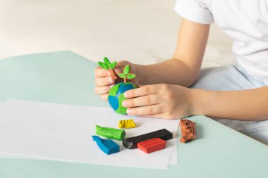 Çocuk hamuru dünya ve ağaçlar sculpts. Planet çocuk avuç içi düzeni. Kavram ekoloji.