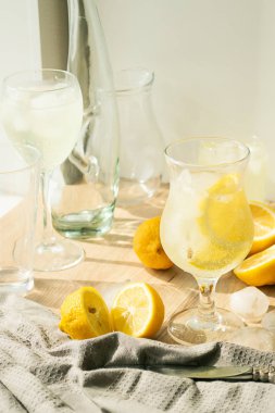 Bardak taze limon ve buz küpleri şeffaf cam hafif bir arka plan canlandırıcı yaz. Ev yapımı mahito veya Detoks.