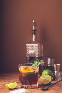 Koyu kahverengi arka plan üzerinde cam kadehler rom ve kola buz küpleri ve kireç Kokteyl. Güçlü alkollü içecek.