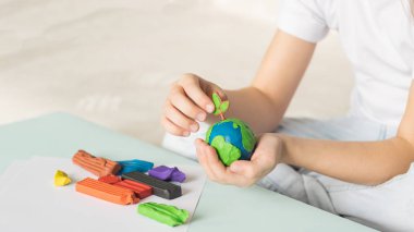 Çocuk plastikin dünya ve ağaçlar sculpts. Çocuk avuç içinde gezegenin konumu. Ekoloji konsepti.