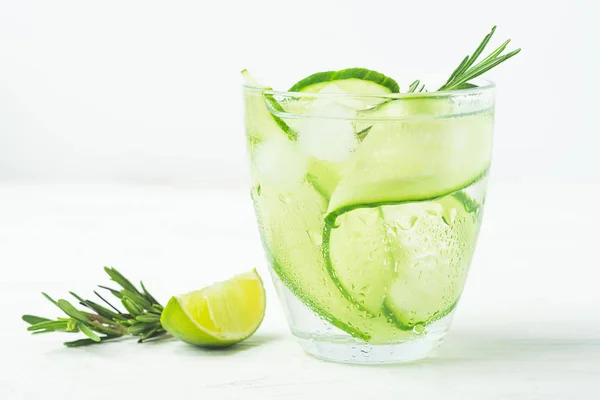 Drink from fresh cucumber juicy lime sprig of rosemary in a glass goblet on a white background. Summer refreshing detox. — Stock Photo, Image