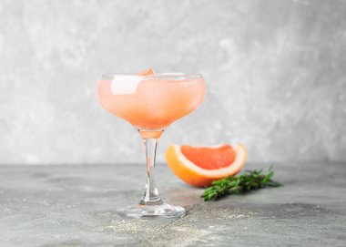 Yaz kokteyl greyfurt biberiye suyu ve buz gri beton zemin üzerine bir cam kadeh içinde yenileniyor. İçki Detoks.