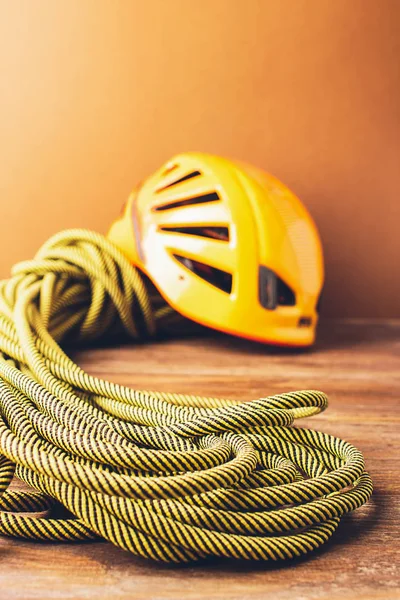 Equipment for high-altitude climbing helmet sports rope on a brown background. Concept of travel and extreme sports.