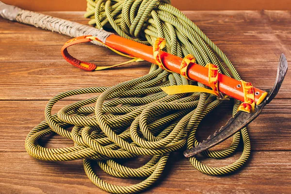 Equipment for high-altitude climbing sports rope and ice ax on a brown background. Concept of travel and extreme sports.