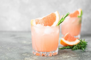 Greyfurt biberiye ve buz suyu zarif cam kadehler gri beton zemin üzerine bir serinletici yaz kokteyl.