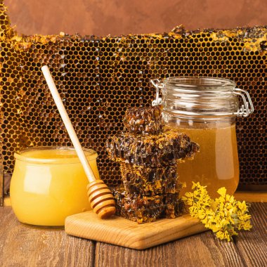 Masada ahşap arka plan üzerinde bir cam kavanoza taze kokulu tatlım. Arı bal farklı türleri. Doğal ürünler.