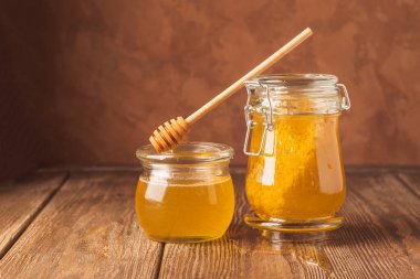Masaahşap arka plan üzerinde farklı cam kavanoz arı bal. Doğal ürünler kavramı. Kopyalama alanı.
