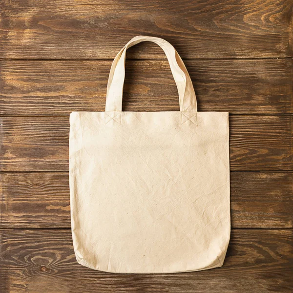 Tas dengan gagang terbuat dari kapas alami untuk produk belanja berlatar belakang kayu. Konsep ekologi. Minimalisme . — Stok Foto