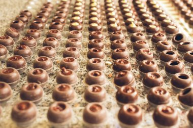 Koyu çikolata şekerler satır özel şekiller düzenlenmiştir. El yapımı çikolatalar pişiriyorum. Seçici odak. Yatay çerçeve.