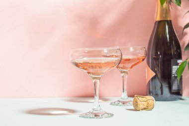 Pembe arka plan parlak ışık üzerinde zarif bardak şampanya veya şarap. Kopya alanı. Seçici odaklama.