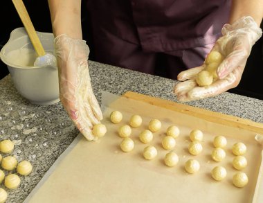 El yapımı çikolata yapma süreci. Pasta şefinin elinde yuvarlak çikolata şekerleri. Seçici odaklama.