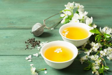 Ahşap bir arka plan üzerinde beyaz forforkovy bardak yaprakları ile kokulu çiçek çay bir fincan. Seçici odak. Kopyalama alanı.