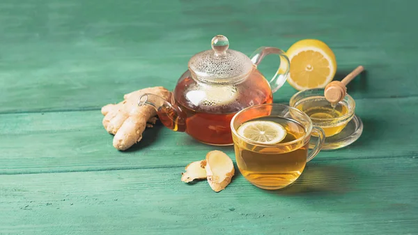 Té de jengibre limón con miel en una taza de vidrio y una tetera sobre un fondo rústico de madera. Bebida saludable para la salud de desintoxicación . — Foto de Stock