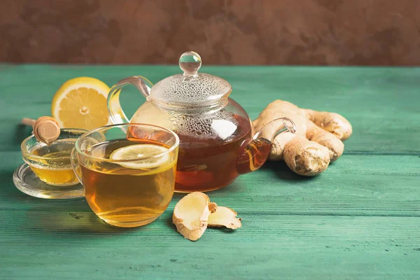 Té de jengibre limón con miel en una taza de vidrio y una tetera sobre un fondo rústico de madera. Bebida saludable para la salud de desintoxicación . — Foto de Stock