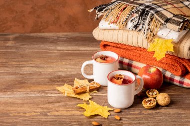 Bir bardak sıcak içecek ve tahta bir arka plan üzerine bir yığın örme giysi. Sonbahar konsepti. Kopya alanı. Seçici odaklama.