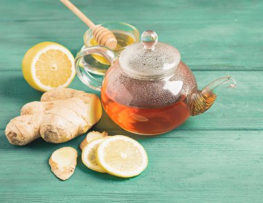 Ahşap rustik bir arka plan üzerinde şeffaf bir çaydanlık bal ile Çay limon zencefil. Detoks sağlığı için sağlıklı içecek.