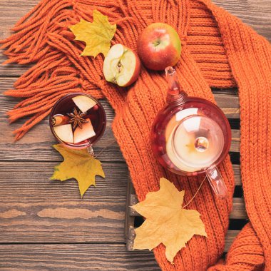 İçecek sonbahar elma kırmızı çilek bir cam çaydanlık ve ahşap bir arka plan üzerinde bir portakal eşarp. Sıcak meyve berry çay.