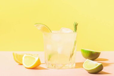 Pastel sarı pembe arka plan üzerinde cam kadehler İtalyan geleneksel içki limoncello. Alkollü kokteyl. Kopyalama alanı.