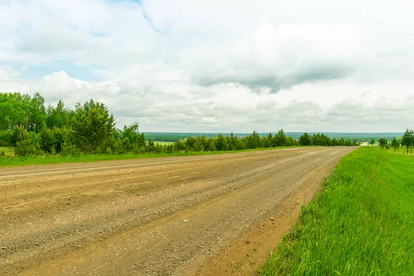 Peyzaj kırsal yol ve mavi gökyüzü. Ufka giden düz çakıl yol.