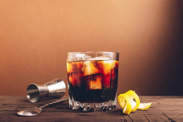 Ein Glas starken alkoholischen Getränks Whiskey Brandy ein Glas mit Eiswürfeln dunklen Holzhintergrund. Selektiver Fokus. — Stockfoto