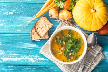 Beyaz kase yakın-up ahşap mavi arka plan kabak ve taze sebze çorbası. Doğal rustik tarz. Sonbahar konsepti.