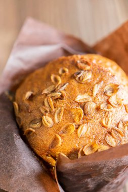 Kahverengi kağıt ambalaj buğday gevreği ile Muffins yakın-up ahşap bir arka plan. Sağlıklı vegan tatlısı. Dikey çerçeve.