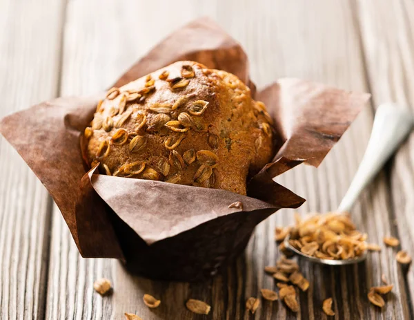 Kahverengi kağıt ambalaj yakın çekim ahşap arka plan buğday gevreği ile Muffins. Sağlıklı vegan tatlısı. Yatay çerçeve.