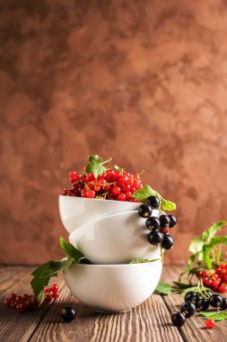 Beyaz kasetaze olgun kırmızı siyah frenk üzümü berry masada bir yığın standı. Seçici odak. Dikey çerçeve