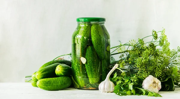 Los pepinos fermentados o enlatados en el frasco de cristal sobre la mesa el fondo claro. Procesamiento de la cosecha de otoño. Alimentos enlatados — Foto de Stock