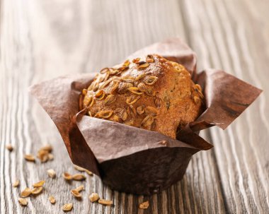 Kahverengi kağıt ambalaj yakın çekim ahşap arka plan buğday gevreği ile Muffins. Sağlıklı vegan tatlısı. Yatay çerçeve.