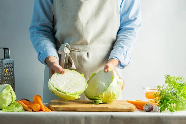 Женщина нарезает свежую органическую капусту для приготовления салата или для соления капусты природным фоном. Вегетарианское питание . — стоковое фото