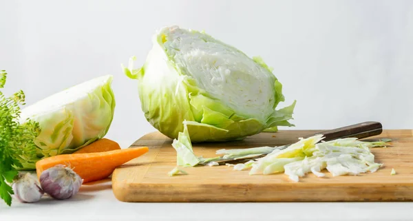 Szerves friss káposzta a főzés saláta vágódeszka a konyhaasztalon természetes háttér. Vegetáriánus étkezési koncepció. — Stock Fotó