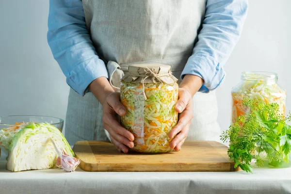 Conservarea fermentației Sauerkraut în borcane de sticlă în mâinile unei femei fundal natural. Conserve alimentare concept . — Fotografie, imagine de stoc